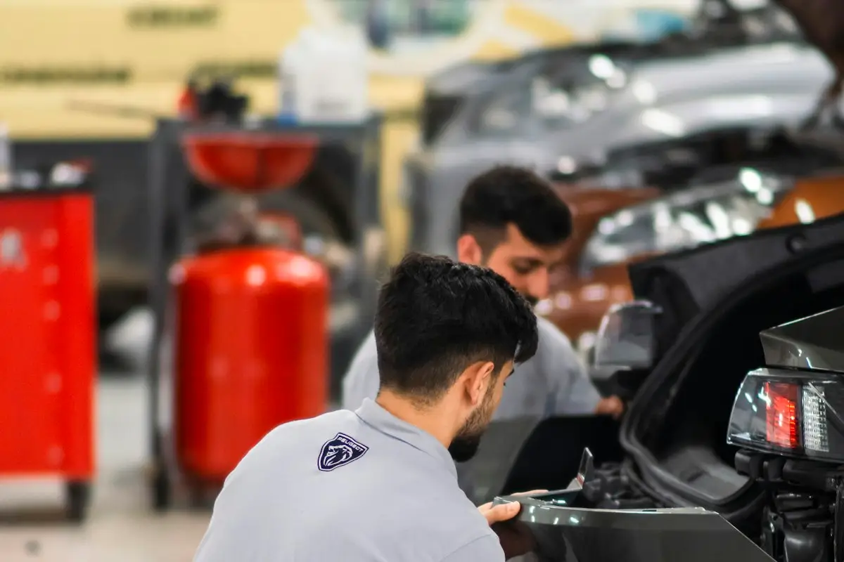 Dois homens trabalhando em um carro em uma garagem