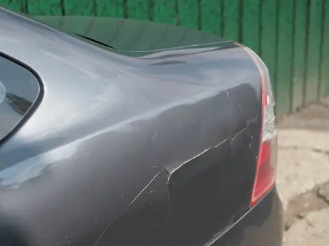 Para-choque cinza danificado do carro com pintura