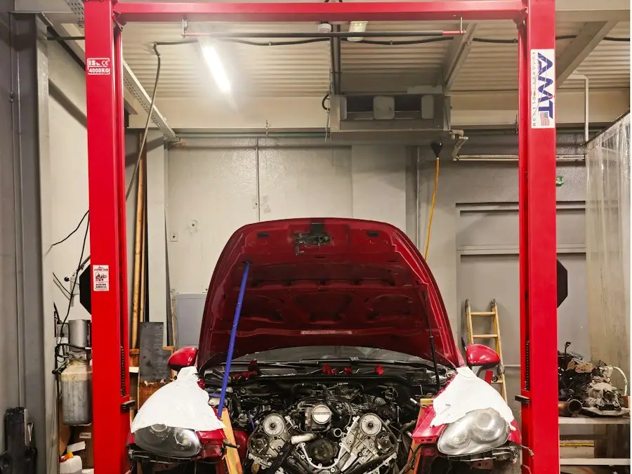 Um carro vermelho com o capô aberto em um elevador